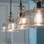 Moderne Pendelleuchten über einem eleganten Küchentisch, die eine gemütliche Atmosphäre schaffen.