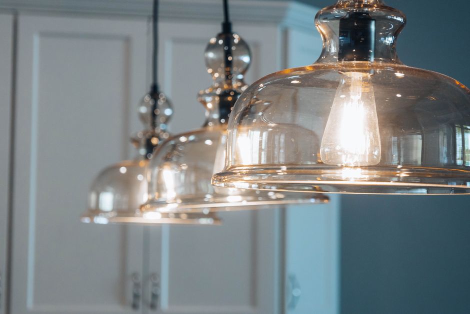 Moderne Pendelleuchten über einem eleganten Küchentisch, die eine gemütliche Atmosphäre schaffen.